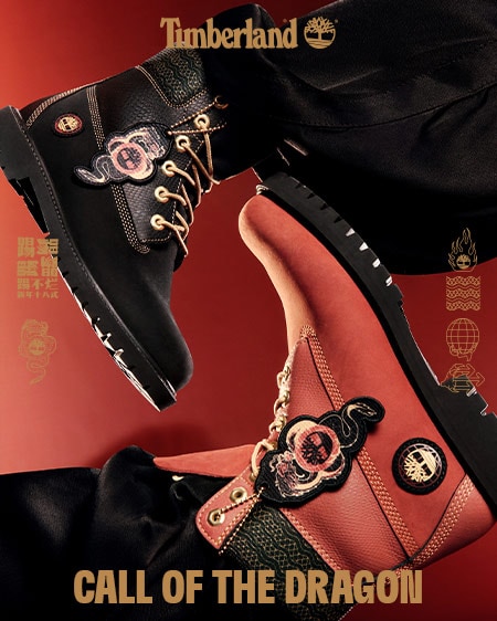 Image shows a bright, dark red background which features two Timberland 6-inch boots in bold black and red with gold accents and gold dragon hangtags, coming in from both sides of the image. Faint gold Chinese characters are visible at the sides of the image.